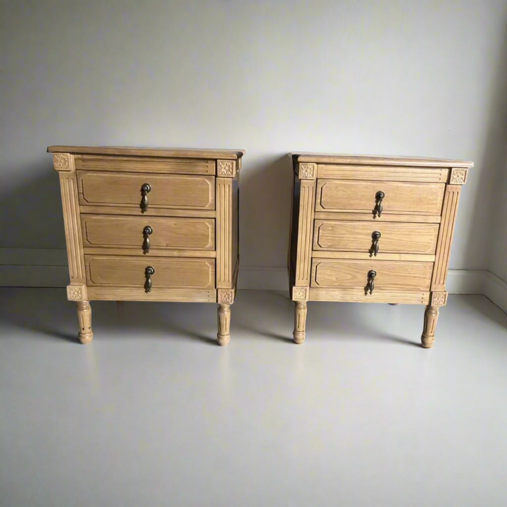 Pair of wooden nightstands with three drawers each on a white background